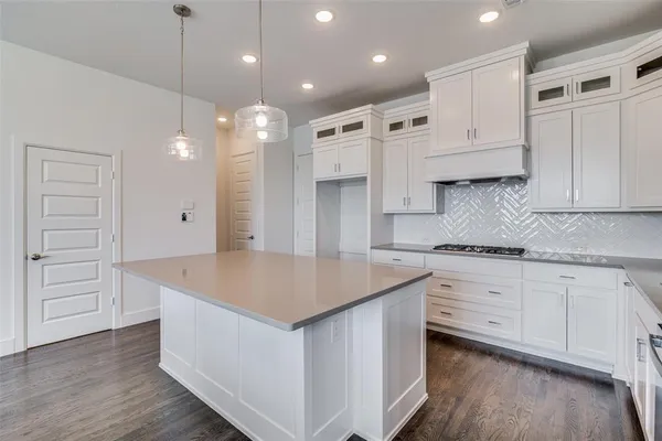 a kitchen with white cabinets and sink
