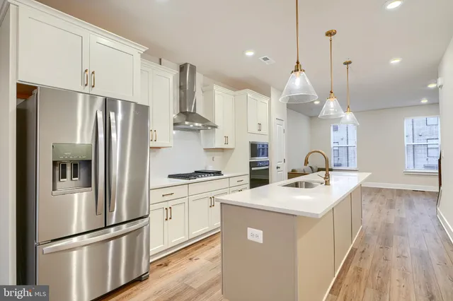 a kitchen with stainless steel appliances granite countertop a sink stove and refrigerator