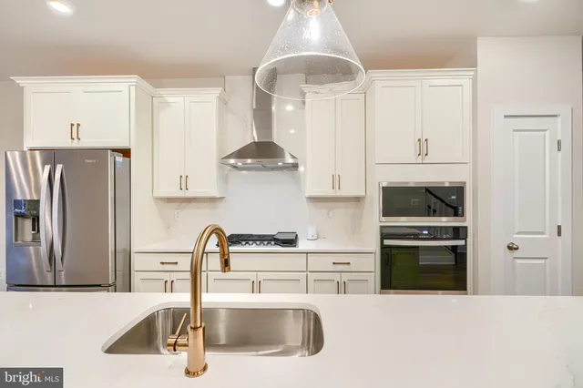 a large kitchen with granite countertop a large counter top space a sink stainless steel appliances and cabinets