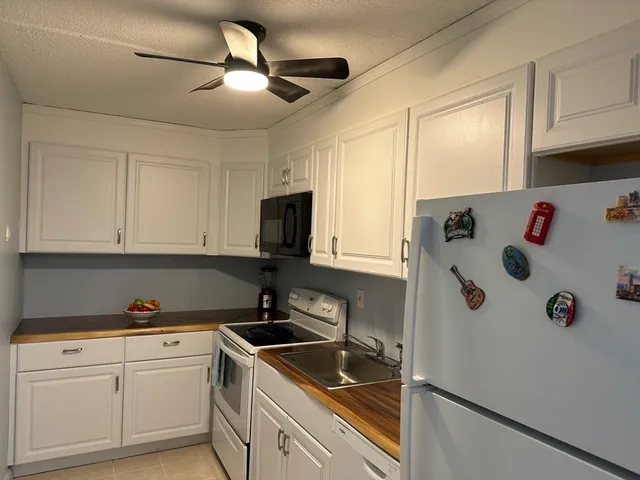 a kitchen with white cabinets and white appliances
