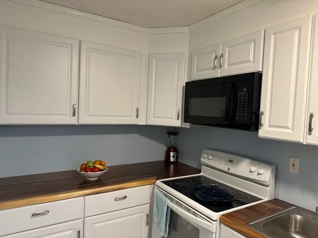 a kitchen with white cabinets and appliances