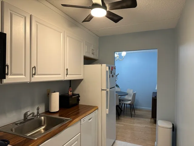 a kitchen with a refrigerator a sink and cabinets