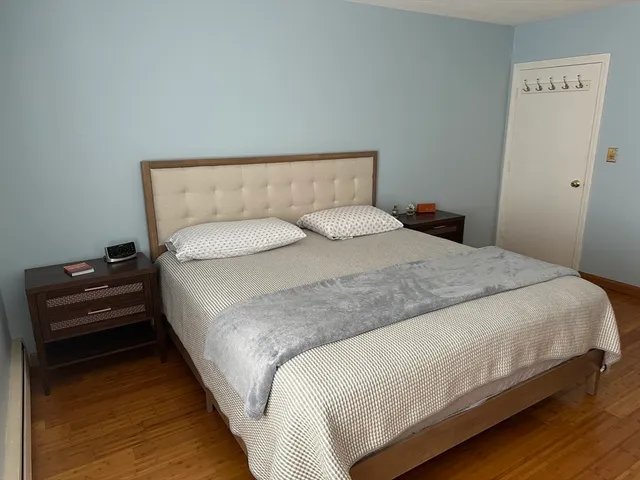 a bedroom with a bed and wooden floor