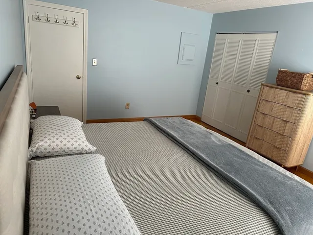 a bedroom with a bed and wooden floor