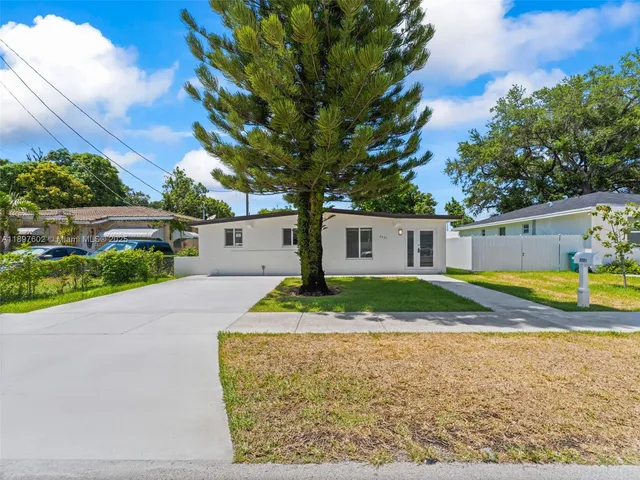 a view of a house with backyard and a tree