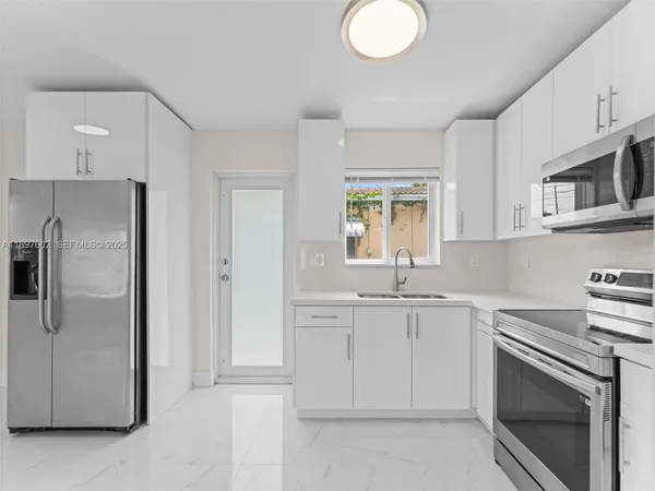 a kitchen with cabinets stainless steel appliances and a counter space