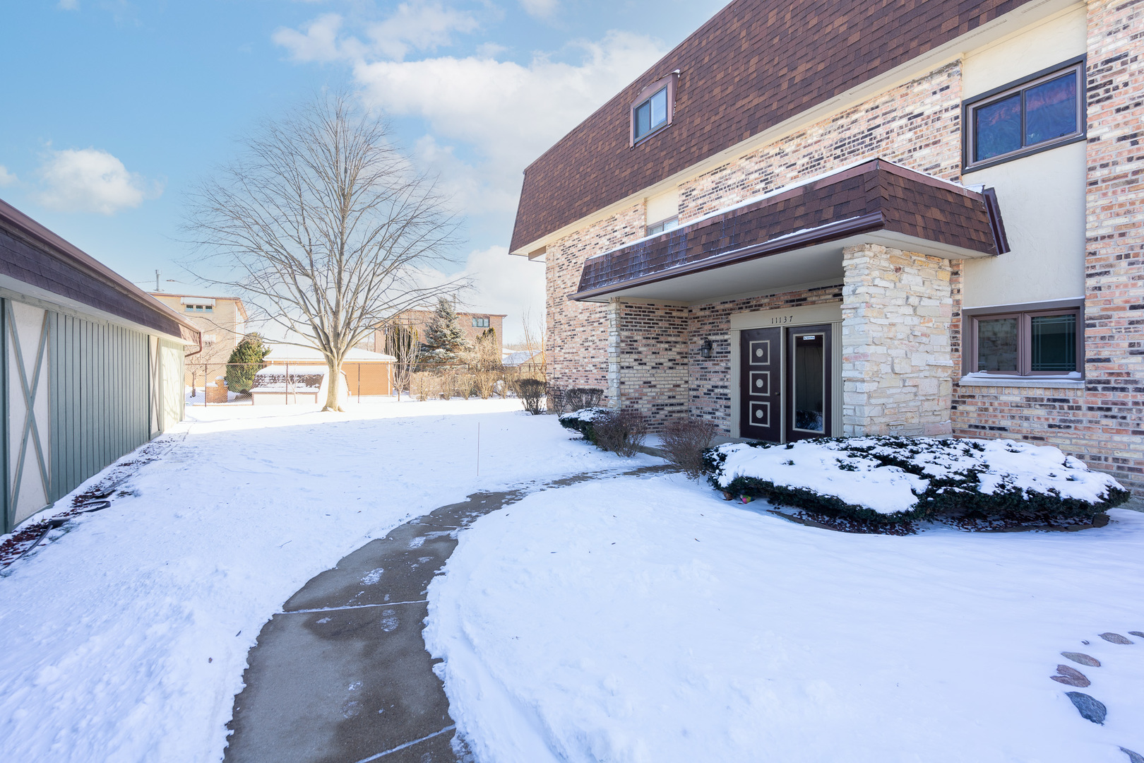 11137 E Road, Unit C Palos Hills, IL 60465 - Photo 4 of 29 a front view of a house with a yard and garage