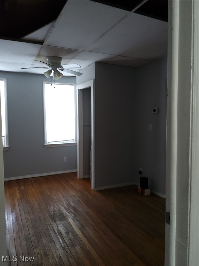 7117 Ottawa Road Cleveland, OH 44105 - Photo 11 of 25 Empty room featuring dark wood-type flooring, a paneled ceiling, and ceiling fan