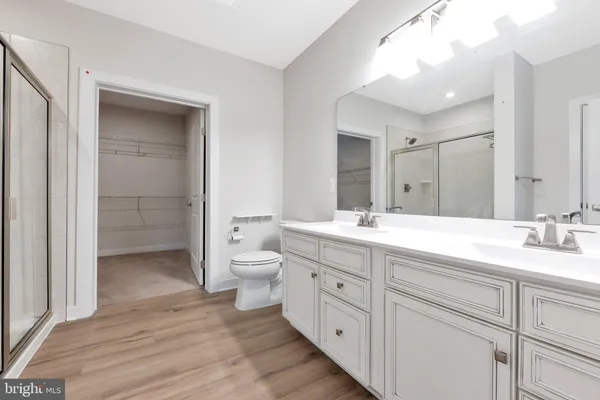 a bathroom with a sink a toilet and a large mirror