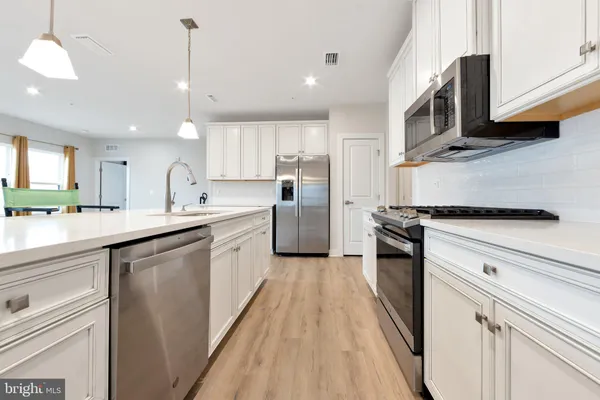 a kitchen with stainless steel appliances kitchen island granite countertop a stove a sink and a microwave