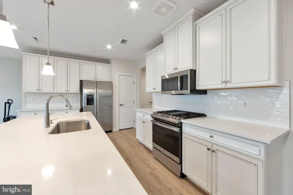 a kitchen with granite countertop a sink stove and refrigerator