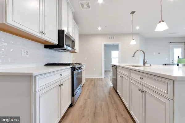 a large kitchen with stainless steel appliances granite countertop a sink and dishwasher a stove with wooden floor