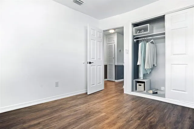 an empty room with wooden floor and closet