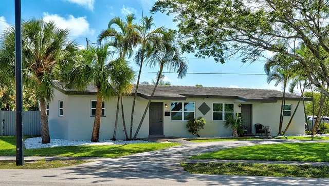 a view of a house with a yard and large tree
