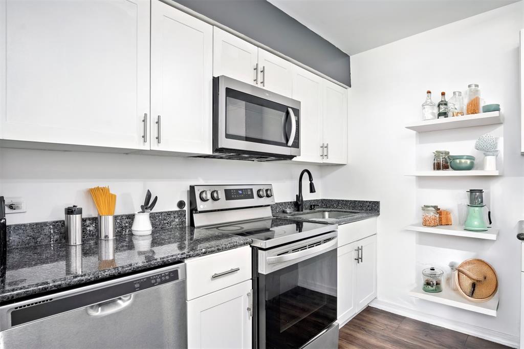 101 Northeast 35th Street, Unit A Pompano Beach, FL 33064 - Photo 6 of 23 a kitchen with stainless steel appliances granite countertop a sink stove and cabinets