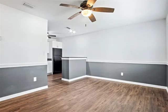 wooden floor in an empty room with a kitchen