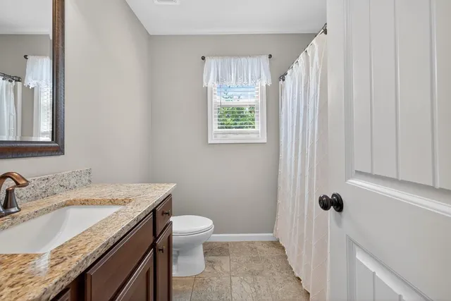 a bathroom with a granite countertop sink toilet and shower