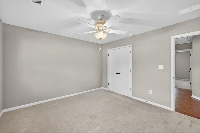 a view of an empty room and a ceiling fan