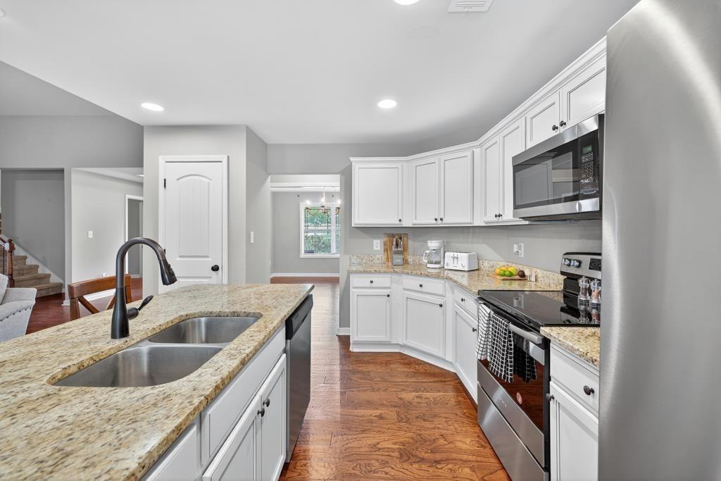 445 Katherine Drive Jefferson, GA 30549 - Photo 36 of 41 a kitchen with stainless steel appliances granite countertop a sink stove and cabinets