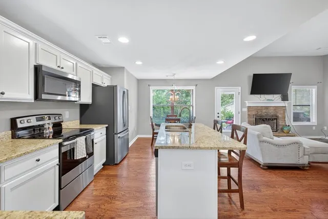 a view of kitchen with microwave a stove and cabinets