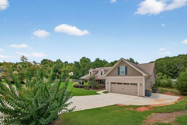 a view of a house with a yard and potted plants