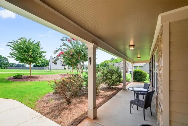 a view of a patio with a table chairs and a yard