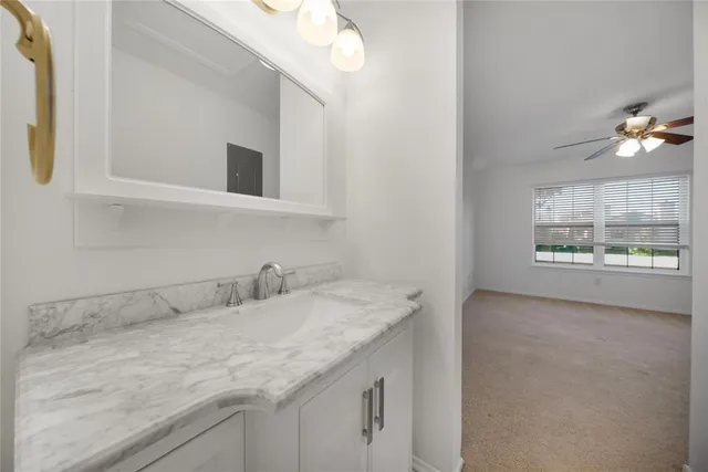 a bathroom with a granite countertop sink a large mirror and a window