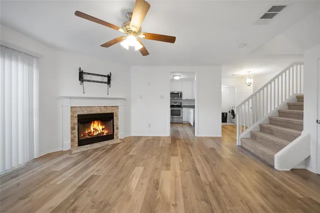 a view of empty room with wooden floor fireplace and a window