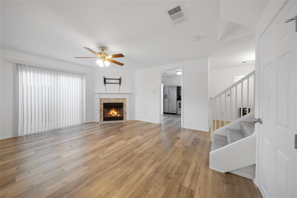 5626 Preston Oaks Road, Unit 16D Dallas, TX 75254 - Photo 3 of 29 an empty room with wooden floor fireplace and windows