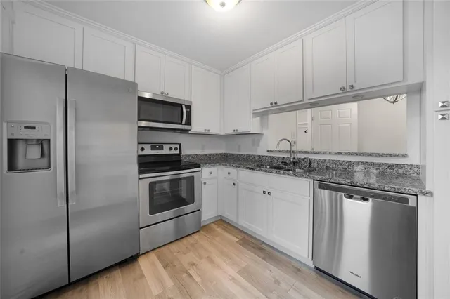 a kitchen with granite countertop a refrigerator stove and microwave
