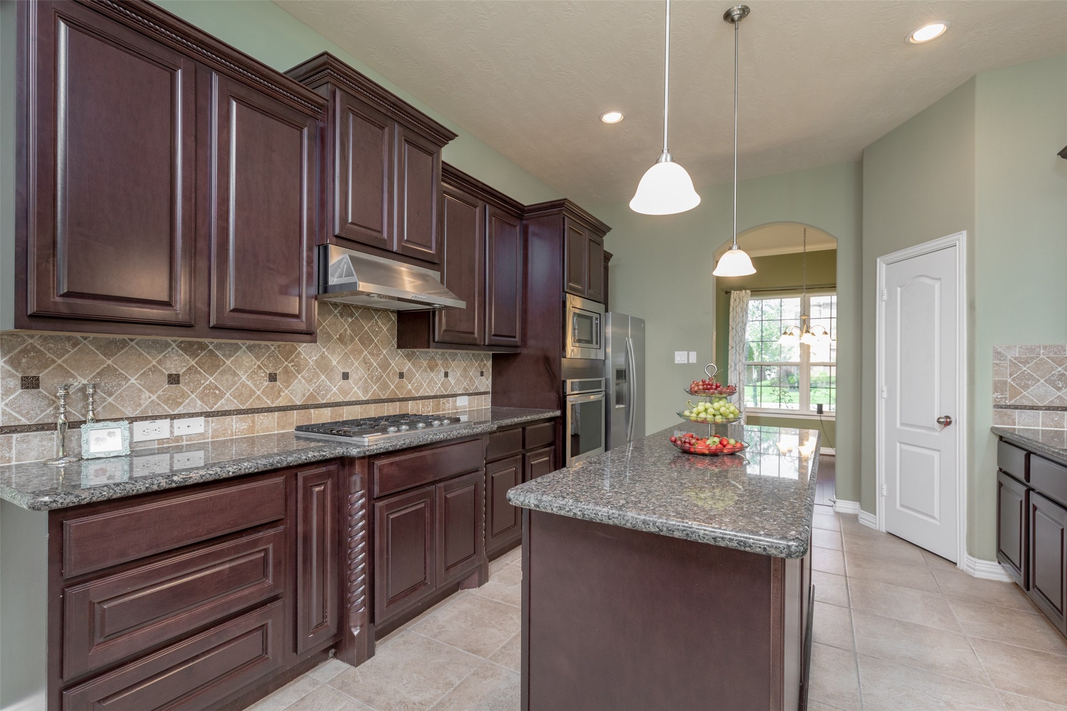 25023 Florina Ranch Drive Katy, TX 77494 - Photo 5 of 12 a kitchen with stainless steel appliances granite countertop wooden cabinets a stove a sink and a granite counter top