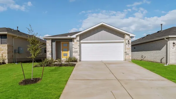 a front view of a house with a yard and trees