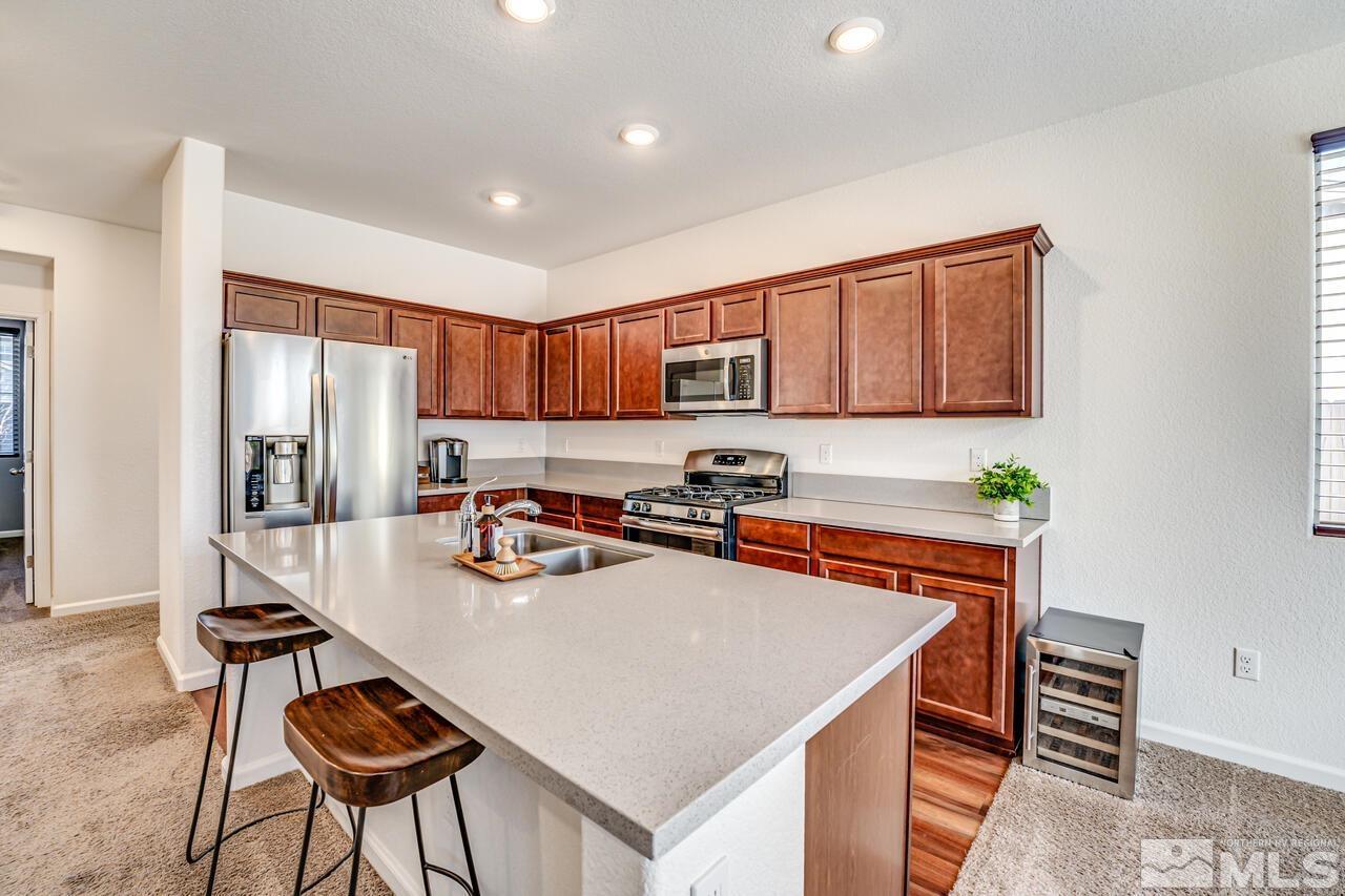 9344 Bay Reno, NV 89506 - Photo 16 of 31 a kitchen with stainless steel appliances a stove a sink a refrigerator cabinets and a dining table