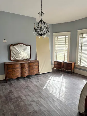 a living room with hard wood floors furniture and a window