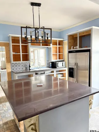 a kitchen with stainless steel appliances granite countertop a refrigerator a stove and a sink