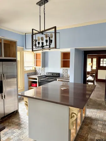 a kitchen with a dining table chairs and white appliances