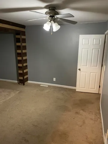 a view of an empty room with a ceiling fan