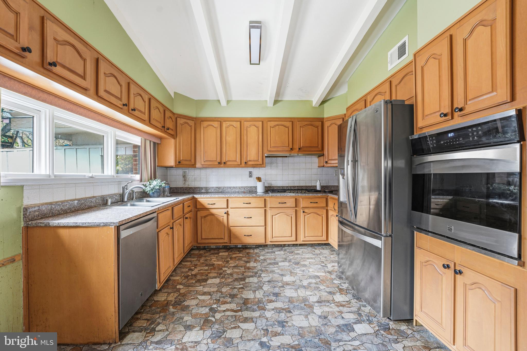 700 Greyrock Drive Silver Spring, MD 20910 - Photo 11 of 48 a kitchen with stainless steel appliances granite countertop a stove a sink and a refrigerator