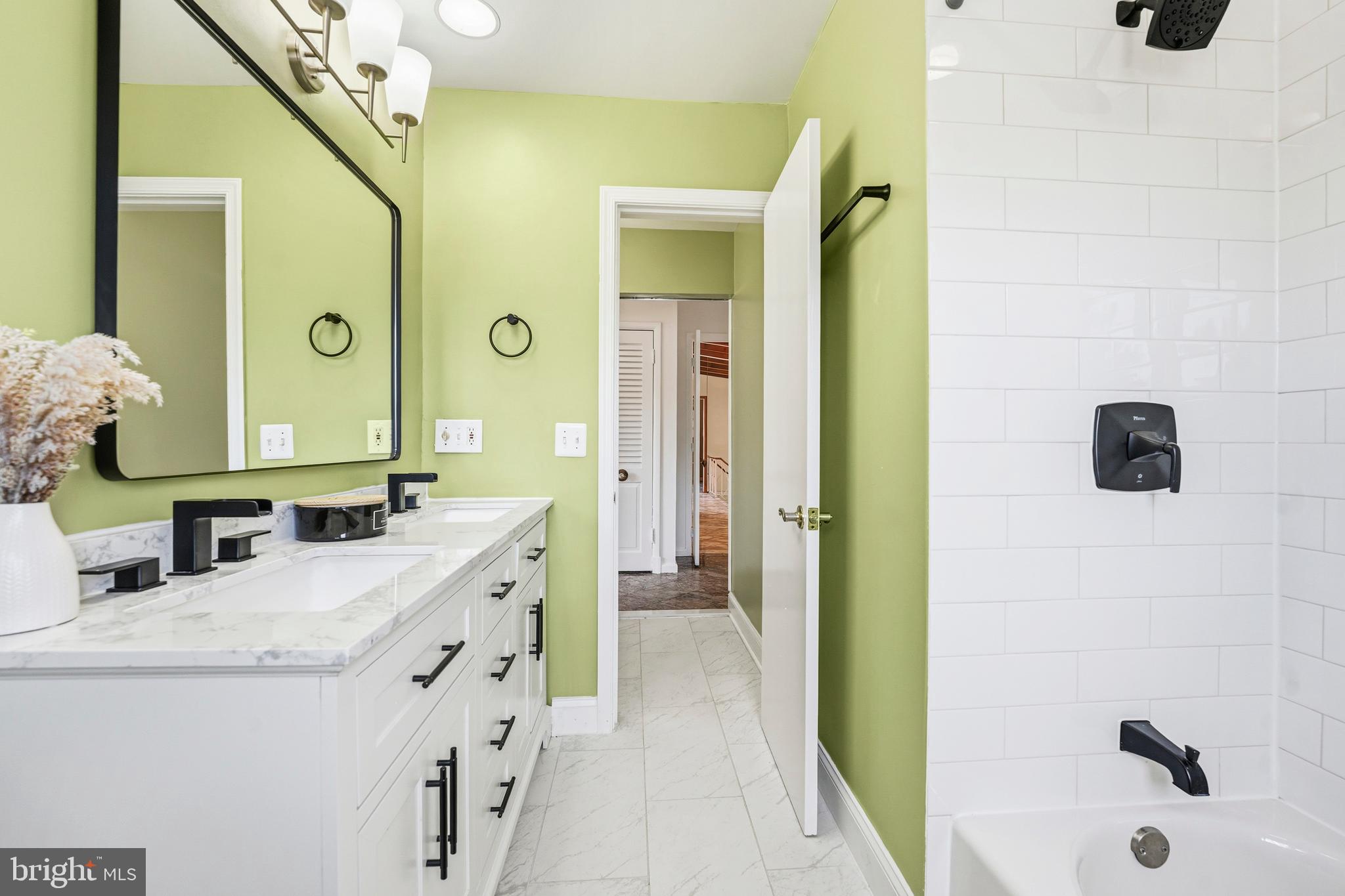 700 Greyrock Drive Silver Spring, MD 20910 - Photo 13 of 48 a bathroom with a granite countertop sink a mirror and a bathtub