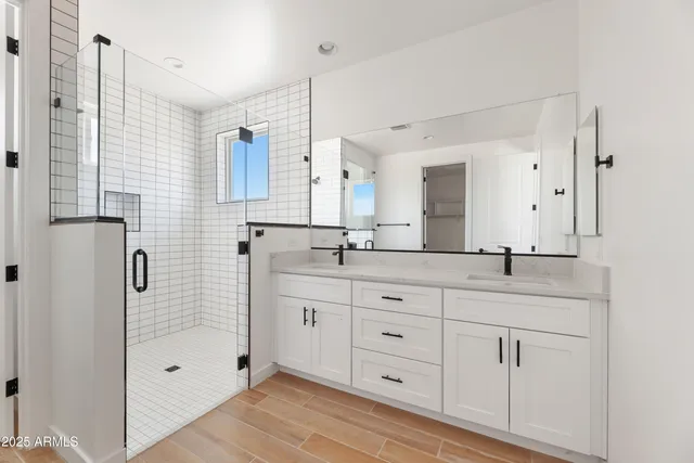 a bathroom with double sink and three mirror
