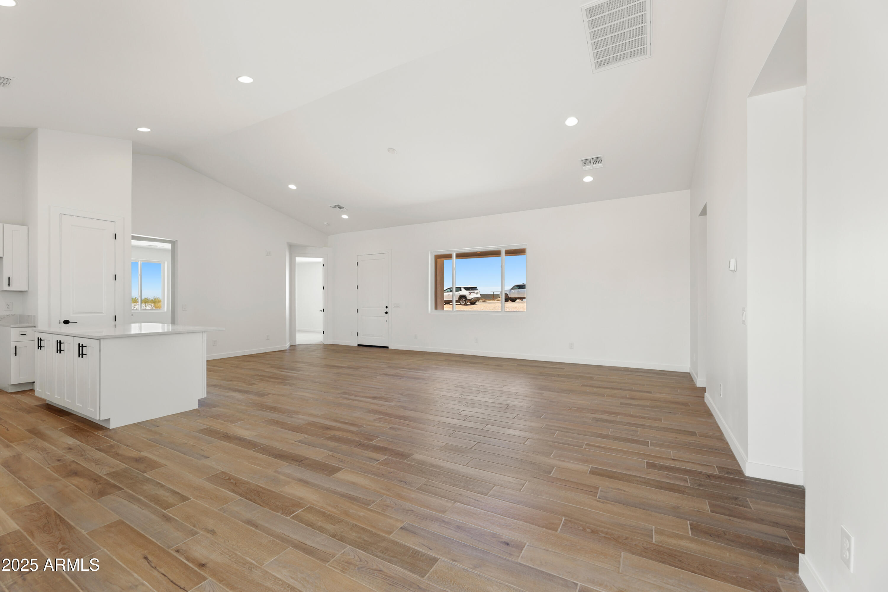 22750 East Roper Lane Florence, AZ 85132 - Photo 9 of 29 an empty room with wooden floor and white walls