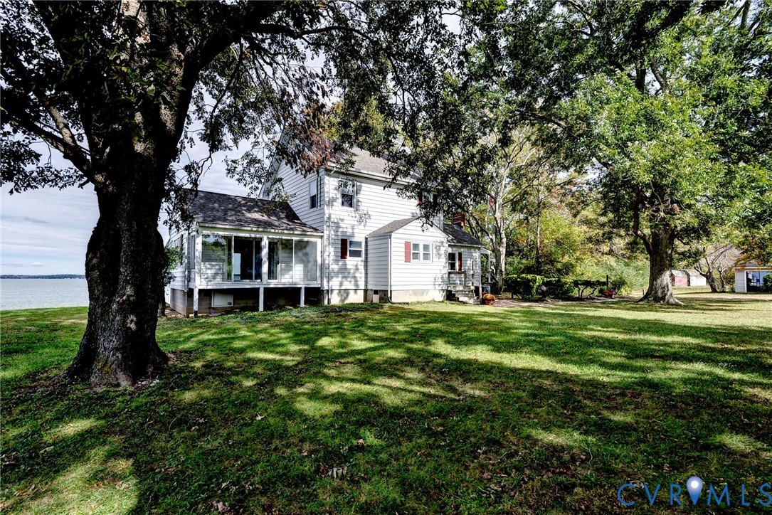 1126 Cloverdale Road Laneview, VA 22504 - Photo 8 of 49 a view of a white house in front of a big yard with large trees