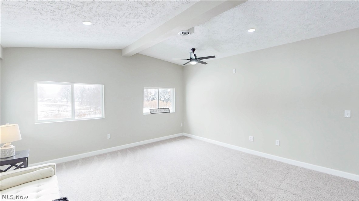 3312 Bancroft Road Akron, OH 44333 - Photo 13 of 50 Unfurnished room with beam ceiling, a textured ceiling, light carpet, and a ceiling fan