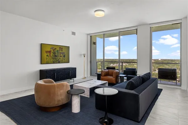 a living room with furniture and a floor to ceiling window