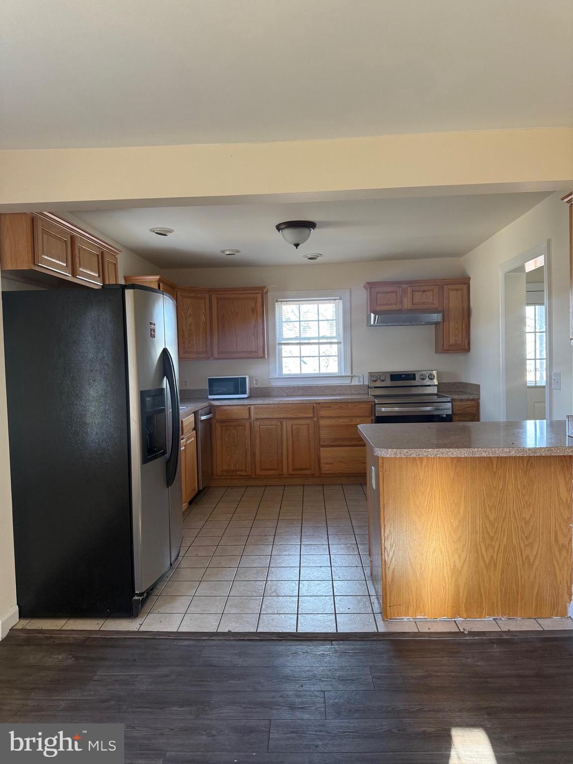 405 1/2 Elm Street Winchester, VA 22601 - Photo 15 of 16 a kitchen with granite countertop a refrigerator and a stove top oven