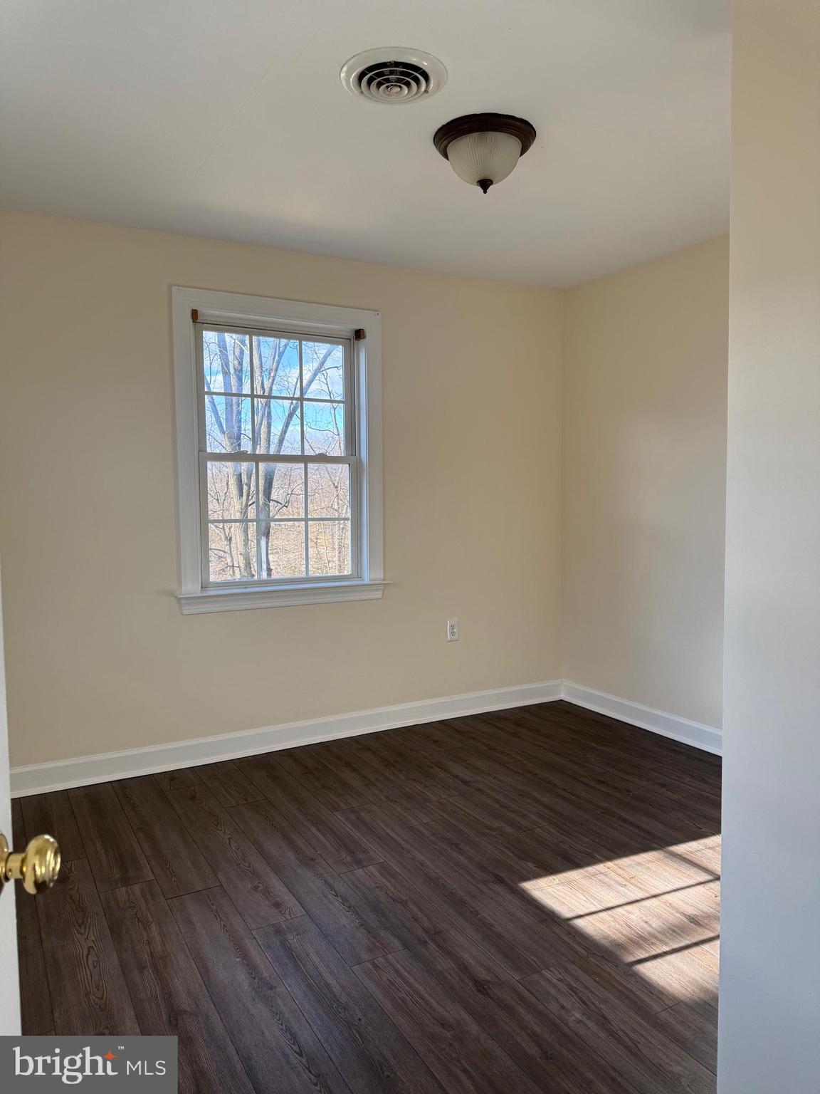 405 1/2 Elm Street Winchester, VA 22601 - Photo 3 of 16 a view of an empty room with wooden floor and a window