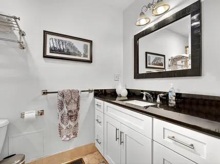 a bathroom with a granite countertop sink mirror and vanity