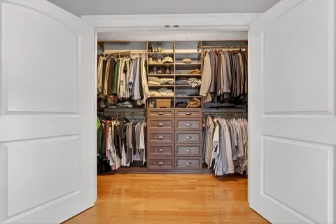 a view of walk in closet with clothes and shoes