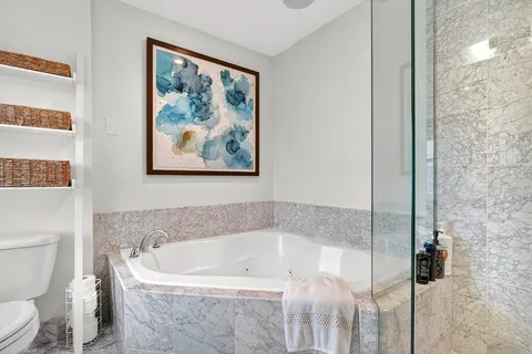 a bath tub sitting next to a white toilet