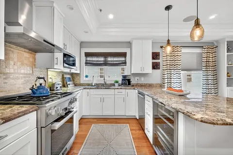 a kitchen with stainless steel appliances granite countertop a sink stove and cabinets